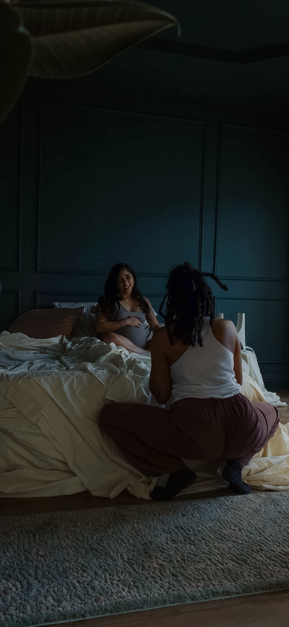 Photographer gently guiding a pregnant client through a pose during a studio maternity session at JPF Galleries, creating a calm and connected experience