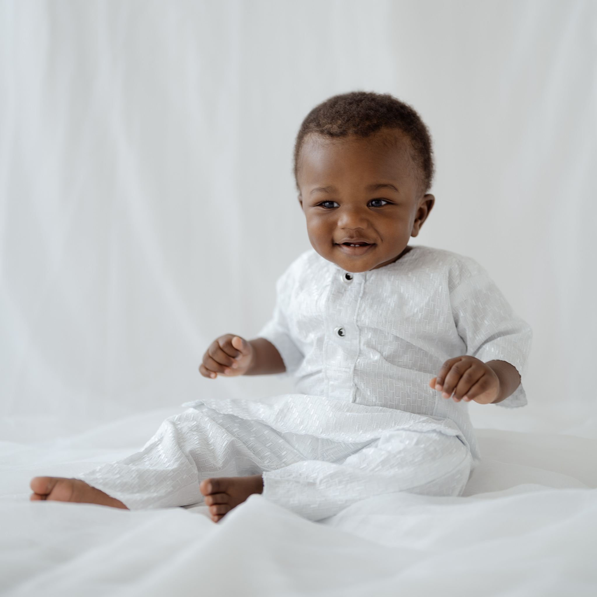 Smiling baby boy during first birthday milestone photos in Fort Worth studio.